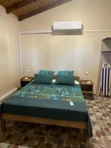 a bedroom with a large bed with blue pillows at Dependance Sainte Marguerite in Le Moule