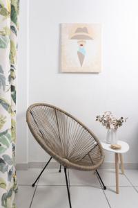 a chair in a room with a table and a picture at Asterios Apartments in Polykhrono +11 photos