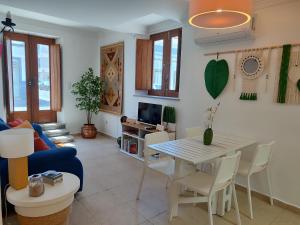 Una sala de estar con un sofá azul y una mesa y sillas. en O Encanto da Vila, en Vila Real de Santo António