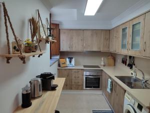 Una cocina con gabinetes de madera y encimera. en O Encanto da Vila, en Vila Real de Santo António