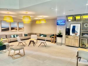 Oscar Freire Hotel RDS Sao Paulo في ساو باولو: غرفة انتظار مع أريكة وطاولات وكراسي