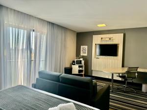 Oscar Freire Hotel RDS Sao Paulo في ساو باولو: غرفة في الفندق مع أريكة زرقاء وتلفزيون