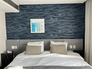 Oscar Freire Hotel RDS Sao Paulo في ساو باولو: غرفة نوم بسرير بجدار ازرق وابيض +25 صورة