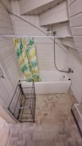 a bath tub in a attic with a shower curtain at Apartments Londa in Jūrmala