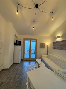 uma sala de estar com um sofá branco e uma cozinha em Attico Mare Taormina with parking em Taormina