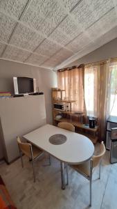 a room with a table and chairs and a tv at Apartments Londa in Jūrmala