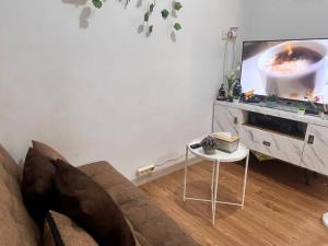 un soggiorno con un divano e una TV di 1BR Rusun Karet Tengsin 2 w Netflix n City View a Giacarta Altre 10 foto
