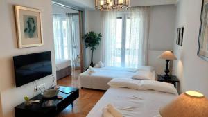 un salon avec deux lits et une télévision à écran plat dans l'établissement Elegant apartment in Acropolis, à Athènes