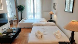 une chambre d'hôtel avec deux lits et une télévision dans l'établissement Elegant apartment in Acropolis, à Athènes