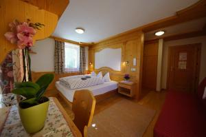 a bedroom with a bed and a table in a room at Chalet Frapes in San Martino in Badia