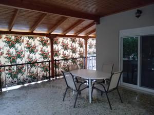 a table and chairs on a balcony with a floral wall at Aris apartment in Salamina
