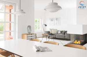 ein weißes Wohnzimmer mit einem Tisch und einem Kamin in der Unterkunft Haus Seepferdchen 238 - Ferienhaus Watt in Juist