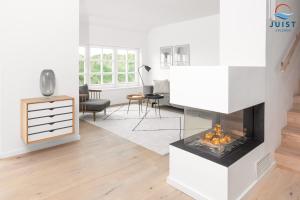 ein Wohnzimmer mit einem Kamin in der Mitte in der Unterkunft Haus Seepferdchen 238 - Ferienhaus Watt in Juist
