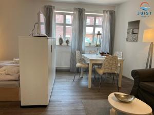 a living room with a table and a dining room at Haus Inselresidenz Strandburg Wohnung S108 in Juist