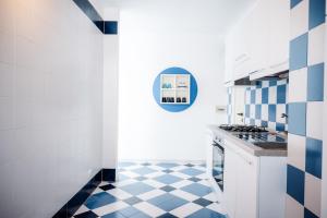 Una cocina con pisos de baldosas azules y blancas y una estufa. en Villa SognoSalento, en Porto Cesareo