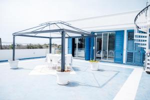 un patio con mesa y sillas bajo un dosel en Villa SognoSalento, en Porto Cesareo