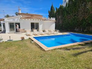 a villa with a swimming pool in front of a house at Villa Silvia LOCDENIA in Denia