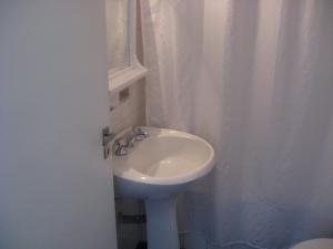 a bathroom with a white sink and a shower curtain at Libertador in Buenos Aires
