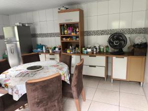 a kitchen with a table and chairs and a refrigerator at Quartos Econômicos in Manaus