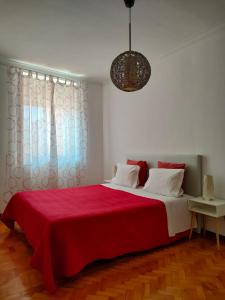 um quarto com uma cama grande com um cobertor vermelho em Apartamento Boavista em Vila Nova de Gaia