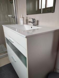 um banheiro com pia branca e espelho em Apartamento Boavista em Vila Nova de Gaia mais 28 fotografias