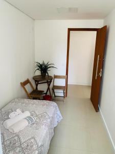 um quarto com uma cama, uma mesa e uma porta em Casa Sagrada 282 em Fortaleza