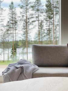 un sofá con una manta delante de una ventana en Villa Forestime, en Lyytilänmäki