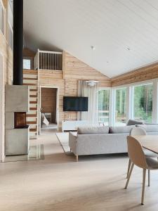 Una sala de estar con un sofá y una chimenea. en Villa Forestime, en Lyytilänmäki