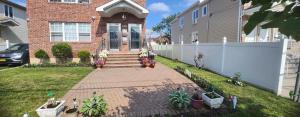 a brick house with a staircase leading to the front door at Osas Luxury Stay in Queens