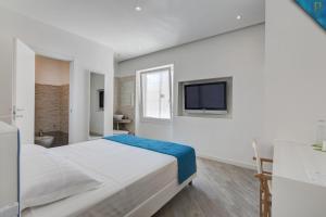 a white bedroom with a large bed and a television at Piccolotel in Rome