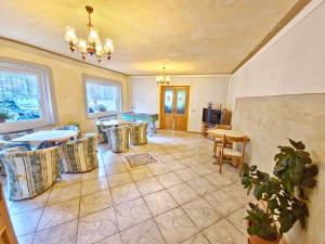 a living room with tables and chairs and a tv at Appartamenti Villa Flora by AMA Val di Fassa in Canazei