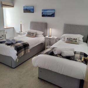 Dos camas una al lado de la otra en un dormitorio. en Darracott Farm Cottage, en Welcombe
