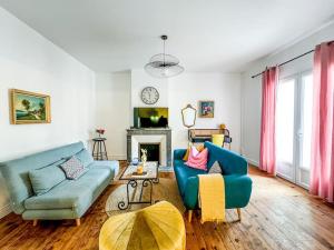 a living room with two blue couches and a fireplace at T3 Familial Pro Tarbes centre in Tarbes