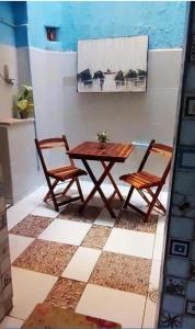 a wooden table and two chairs sitting next to a table at Pousada Terra do Sol in Fortaleza