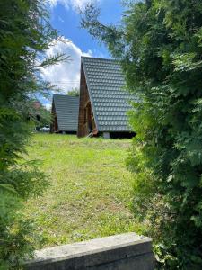 two houses are seen through the trees at Domek nad Solinką II in Wołkowyja +3 photos