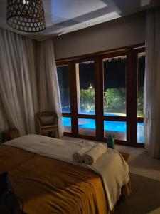a bedroom with a bed and a large window at Casa Tangerina BG, seu Bangalô frente mar em Barra Grande-PI in Barra Grande