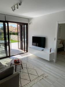 Una sala de estar con un televisor de pantalla plana en una pared. en Caballo de Mar, en Pilar de la Horadada
