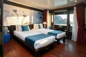 a hotel room with two beds and a window at Bhaya Legend Cruises in Ha Long