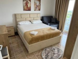 - une chambre avec un grand lit et un canapé dans l'établissement Fishta apartments Q5 34, à Velipojë