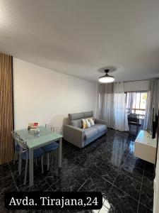 salon z kanapą i stołem w obiekcie Coconoa Beach w mieście Playa del Ingles