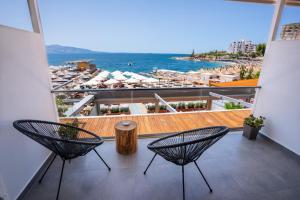 a balcony with two chairs and a view of the beach at Da Luz Boutique Hotel in Sarandë