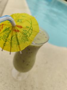 ein gelber Regenschirm in einer Vase auf einem Tresen in der Unterkunft Ile des Plaisirs - Domaine de Charme et table d'hôtes Caraïbéenne in Graulhet