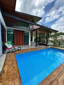 a swimming pool in front of a house at Mountain hills house poolvilla saraburi muaklek in Ban Sap Phrik