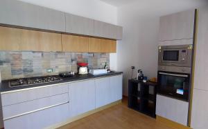 a kitchen with a stove and a microwave at La Casa di Niña in Augusta