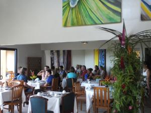a group of people sitting at tables in a restaurant at Tiki Hôtel - Hôtel d'application du Lycée de Tahiti in Punaauia