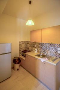 a kitchen with a white refrigerator and a sink at Blue Horizon Studios in Vasilikos
