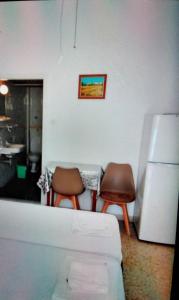 a kitchen with two chairs and a refrigerator at Giannis Rooms in Methana