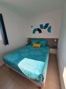 Un dormitorio con una cama con un edredón azul. en Lou Mas Azur, en Le Lavandou