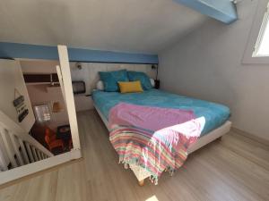 a small bedroom with a bed and a staircase at Lou Mas Azur in Le Lavandou