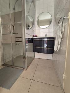 y baño con ducha, lavabo y espejos. en Lou Mas Azur, en Le Lavandou